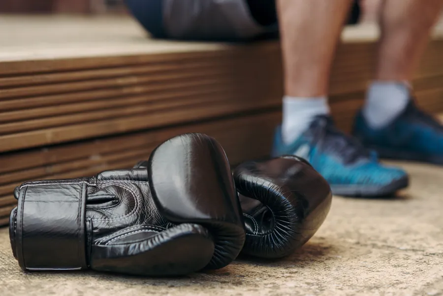 A pair of black boxing gloves resting on the studio floor